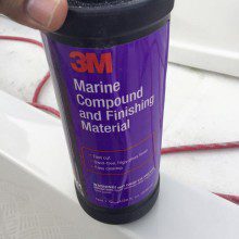 A person holding a bottle of marine compounding material.
