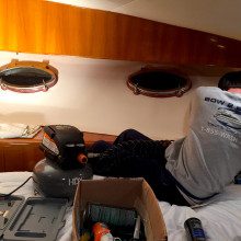 A man is working on a boat in a bedroom.