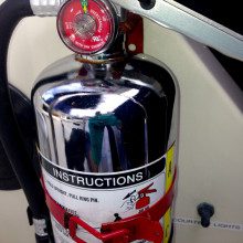A fire extinguisher is attached to a vehicle.