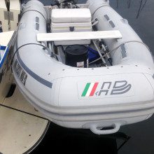 A boat with an inflatable dinghy docked next to it.