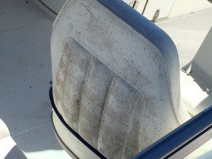 The seat of a boat is covered in dirt and grime.