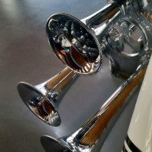 A pair of chrome trumpets on a table.