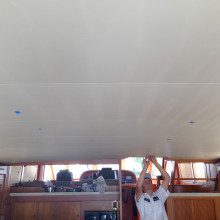 A man standing on the ceiling of a boat.