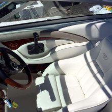 A white boat with a steering wheel and steering wheel.